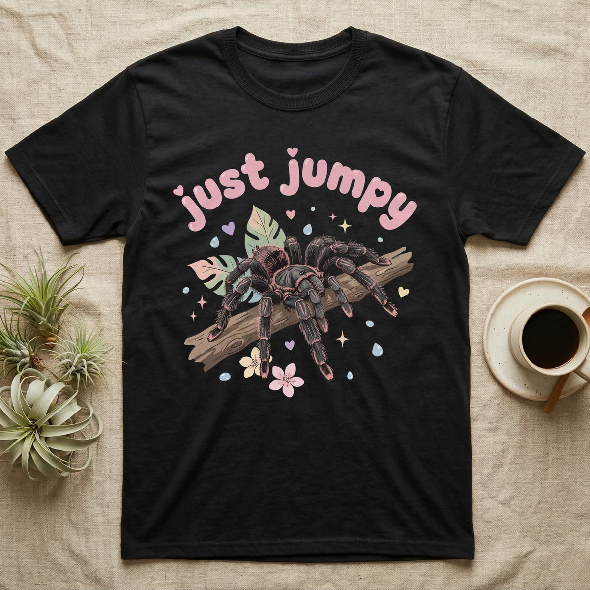 Pink Toe Tarantula Softie T-Shirt in Black — Pink toe tarantula poised to leap on a branch under a puffy pastel "just jumpy" bubble wordmark with tiny hearts.
