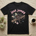 Pink Toe Tarantula Softie T-Shirt in Black — Pink toe tarantula poised to leap on a branch under a puffy pastel "just jumpy" bubble wordmark with tiny hearts.