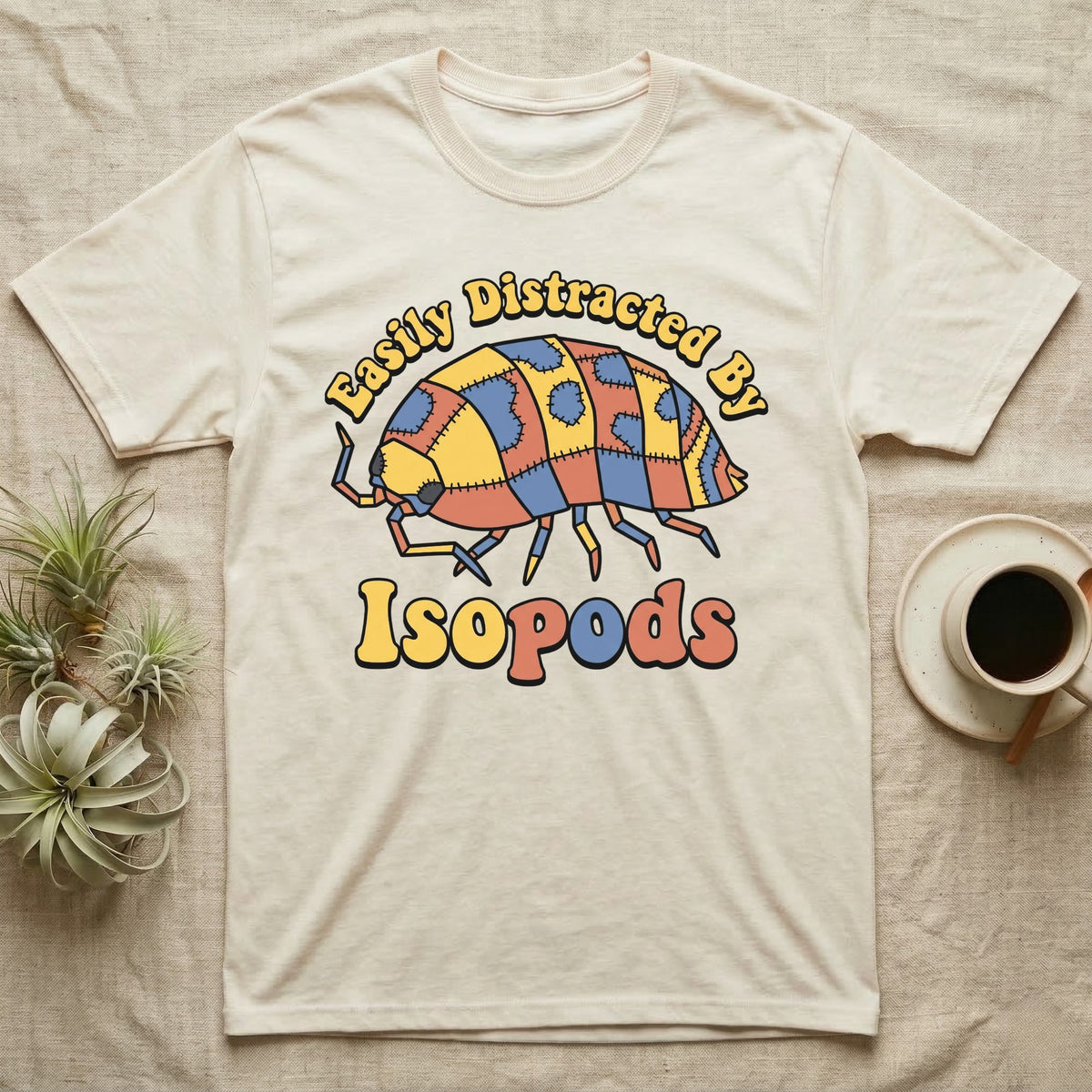 Dairy Cow Isopod Patchwork T-Shirt in Natural — Quilt-patchwork dairy cow isopod in mustard and denim under retro "Easily Distracted By Isopods" text.