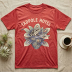 Tadpole Hotel Frog T-Shirt in Heather Red — Whimsical naturalist illustration of a dart frog tucking tadpoles into a bromeliad Tadpole Hotel with hand-lettered marquee text.