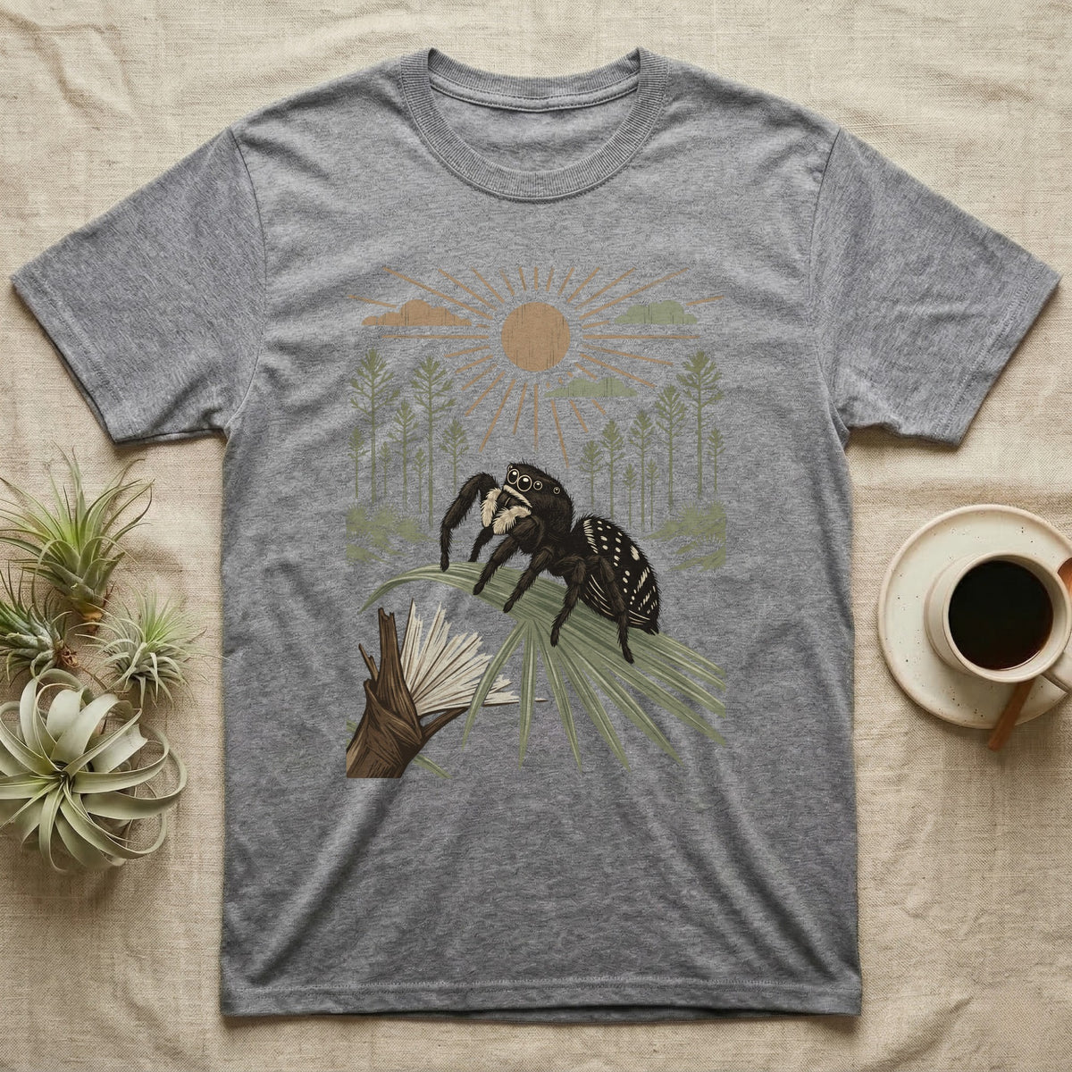 Jumping Spider Home Range T-Shirt in Sport Grey — Woodcut-style illustration of a regal jumping spider perched on a saw palmetto blade with pines behind, no on-shirt text.