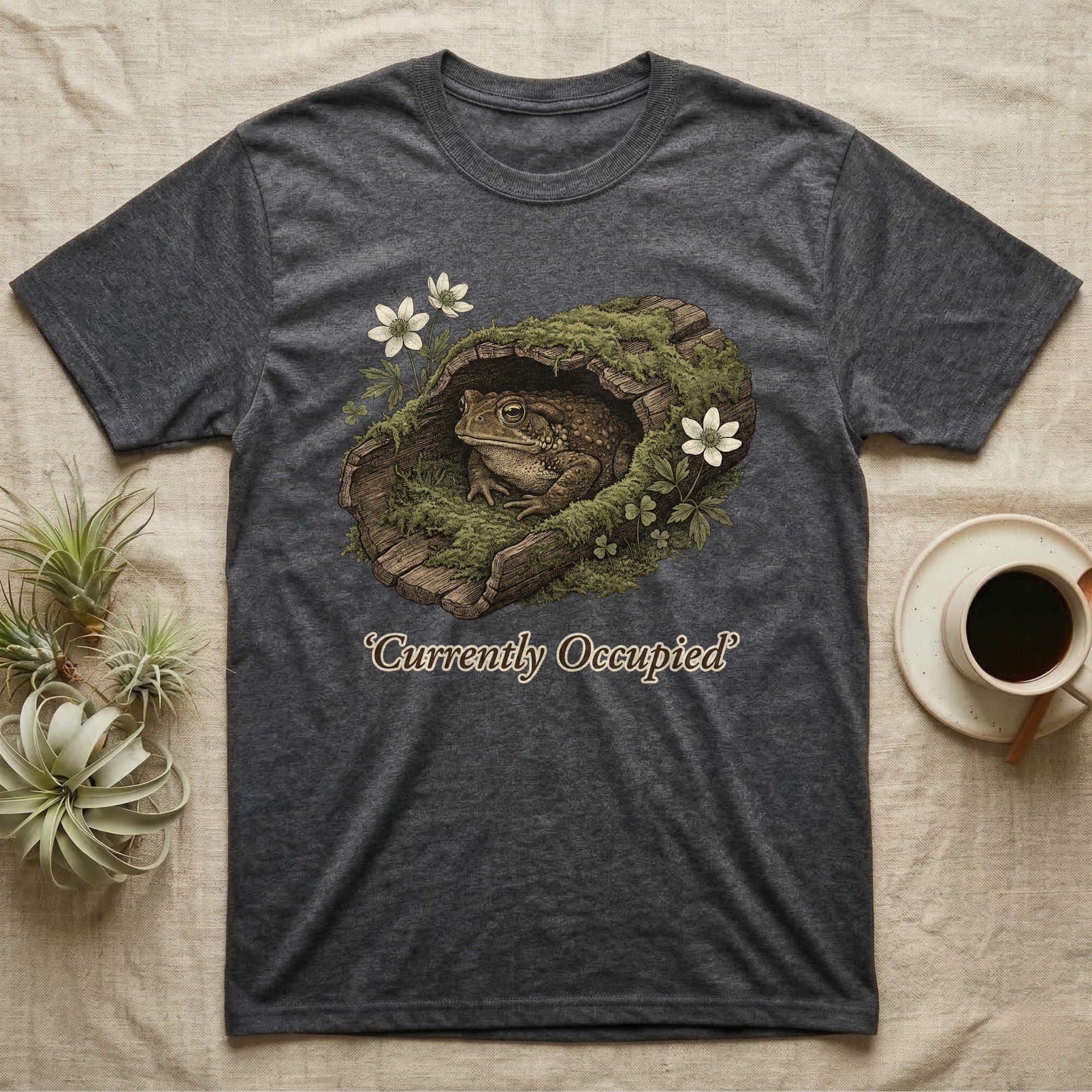 Dark gray t-shirt with a toad in a mossy log design and text.