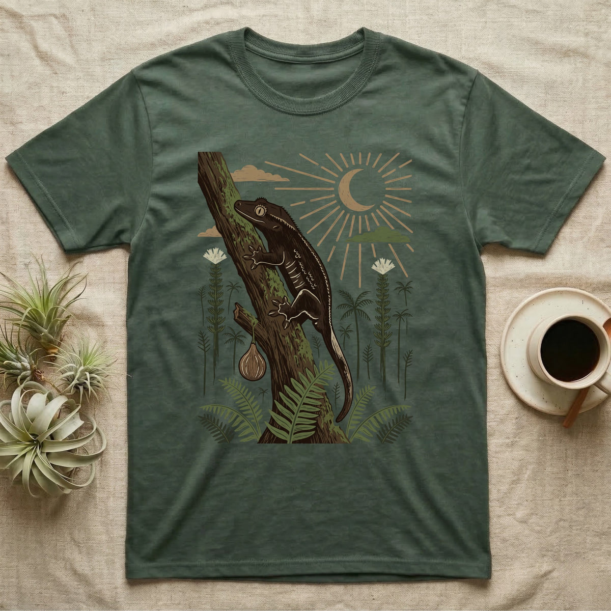 Crested Gecko Home Range T-Shirt in Military Green — Woodcut-style illustration of a crested gecko clinging head-up to a mossy rainforest trunk among tree ferns, no on-shirt text.