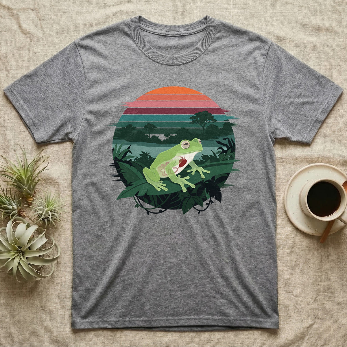 Glass Frog See-Through T-Shirt in Sport Grey — Flat-colour circle-window illustration of a glass frog silhouetted crossing a rainforest canopy scene.
