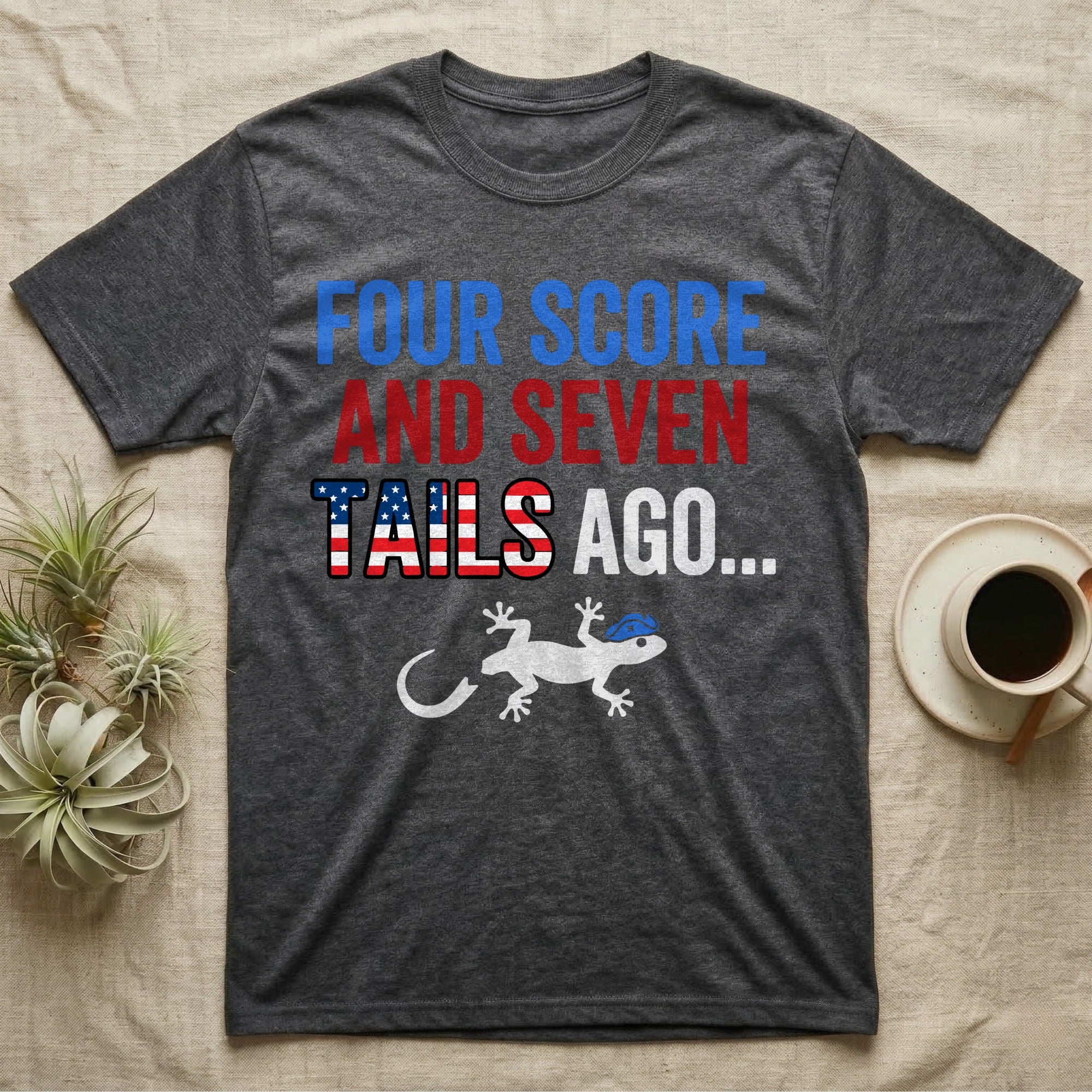 Gecko Four Score T-Shirt in Dark Heather — Block text Four Score and Seven Tails Ago with a flag-filled word above a white gecko silhouette shedding its tail.