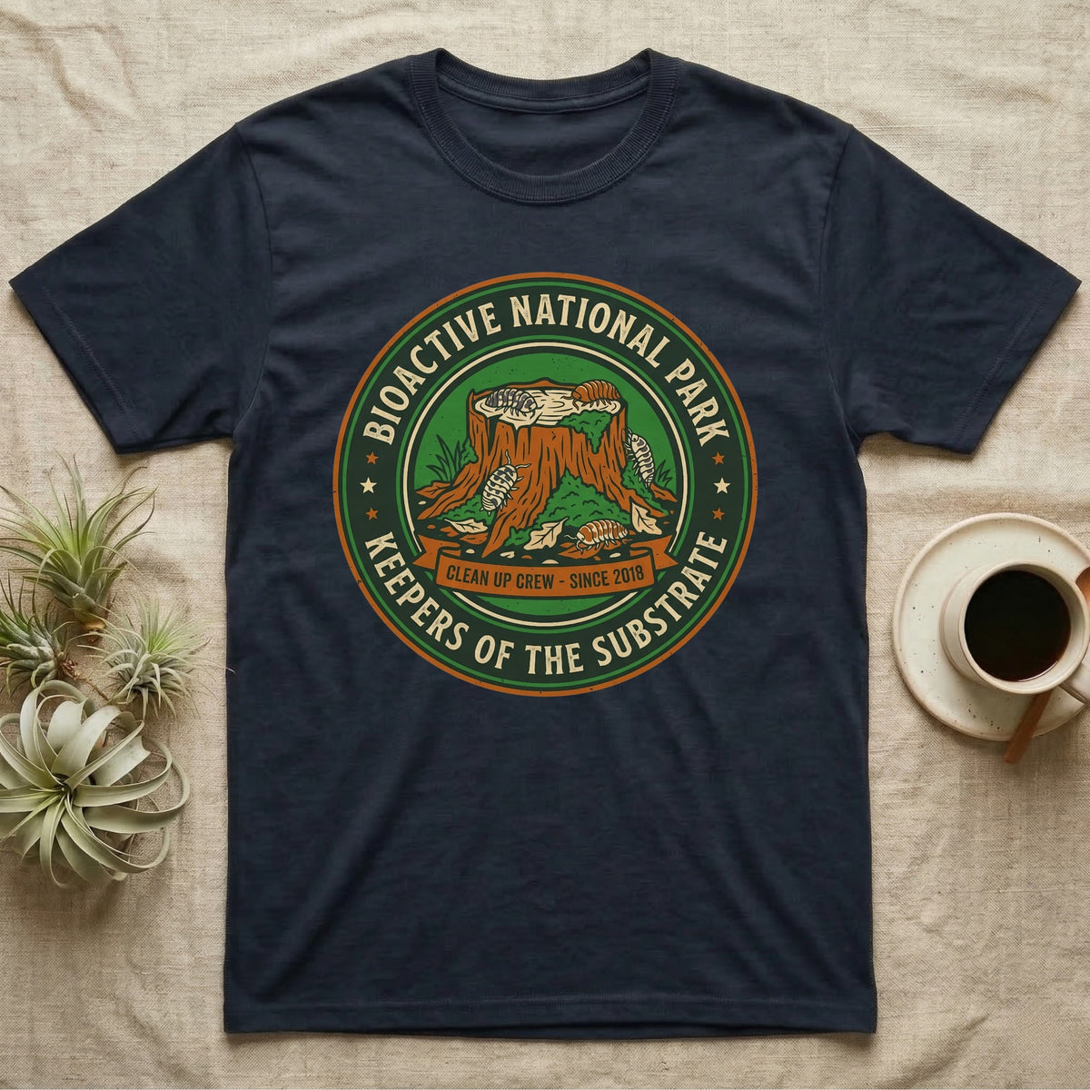 Isopod Keepers of the Substrate T-Shirt in Navy — Weathered green park badge with isopods working a mossy stump and leaf litter, cream arc lettering.