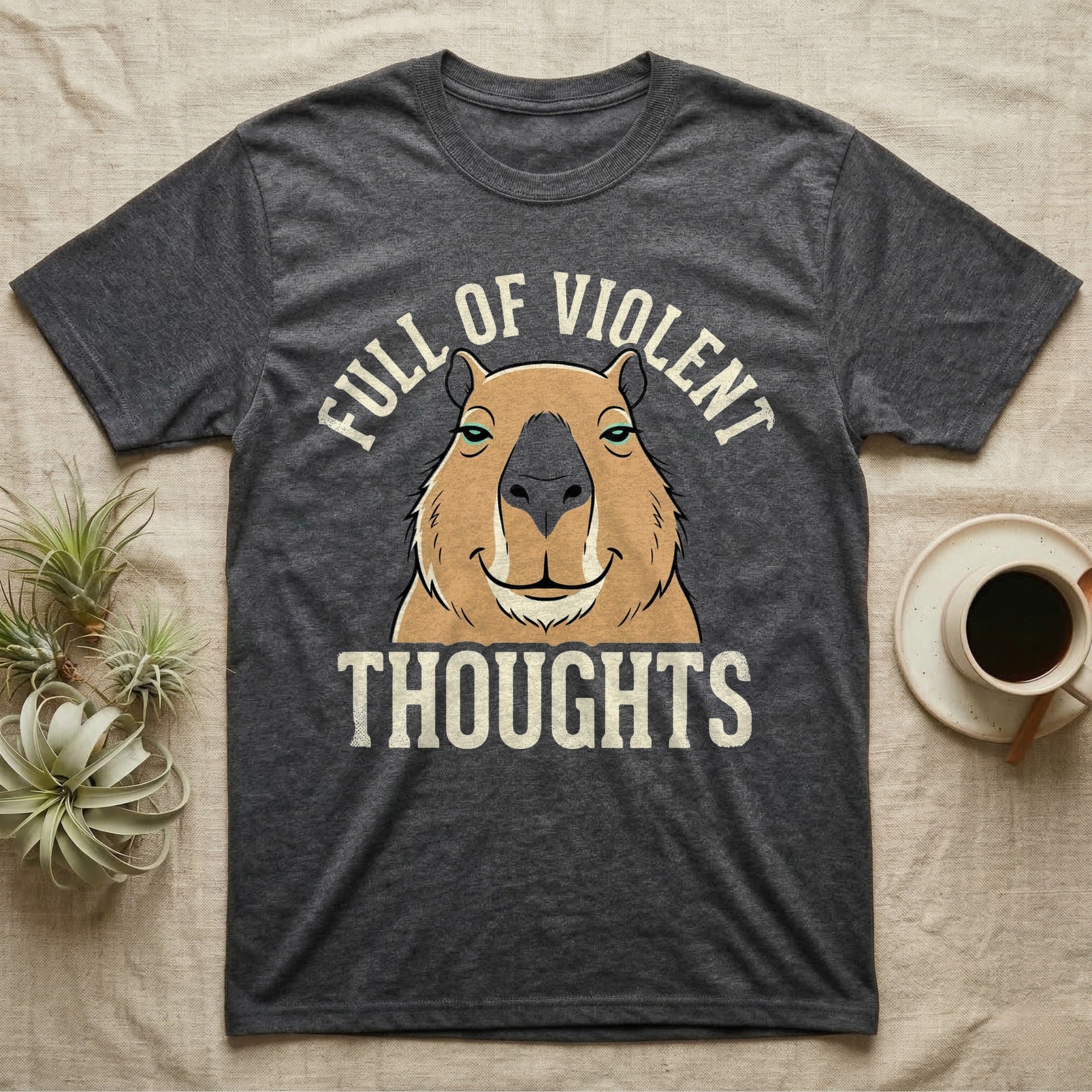 Capybara Violent Thoughts Tee in Dark Heather — Vector-bold portrait of a serenely half-smiling capybara framed by cream slab typography reading "Full Of Violent Thoughts."