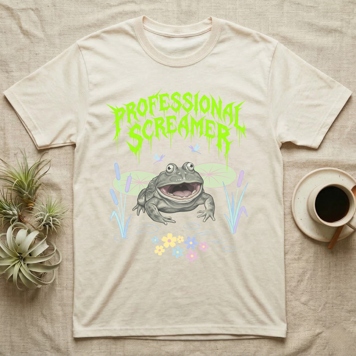Budgett's Frog Feral T-Shirt in Natural — Budgett's frog with wide screaming mouth under jagged acid-green metal text PROFESSIONAL SCREAMER with lily pads