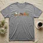Crested Gecko Morph Line T-Shirt in Sport Grey — Five crested gecko morphs in ink and watercolour perched along one cork bark branch with ficus leaves.
