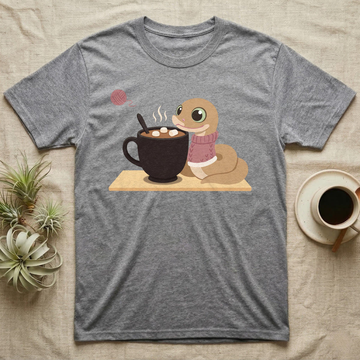 Hognose Snake Knitted Sweater T-Shirt in Sport Grey — Soft-painted illustration of a hognose snake in a knitted jumper resting beside a mug of cocoa with marshmallows.
