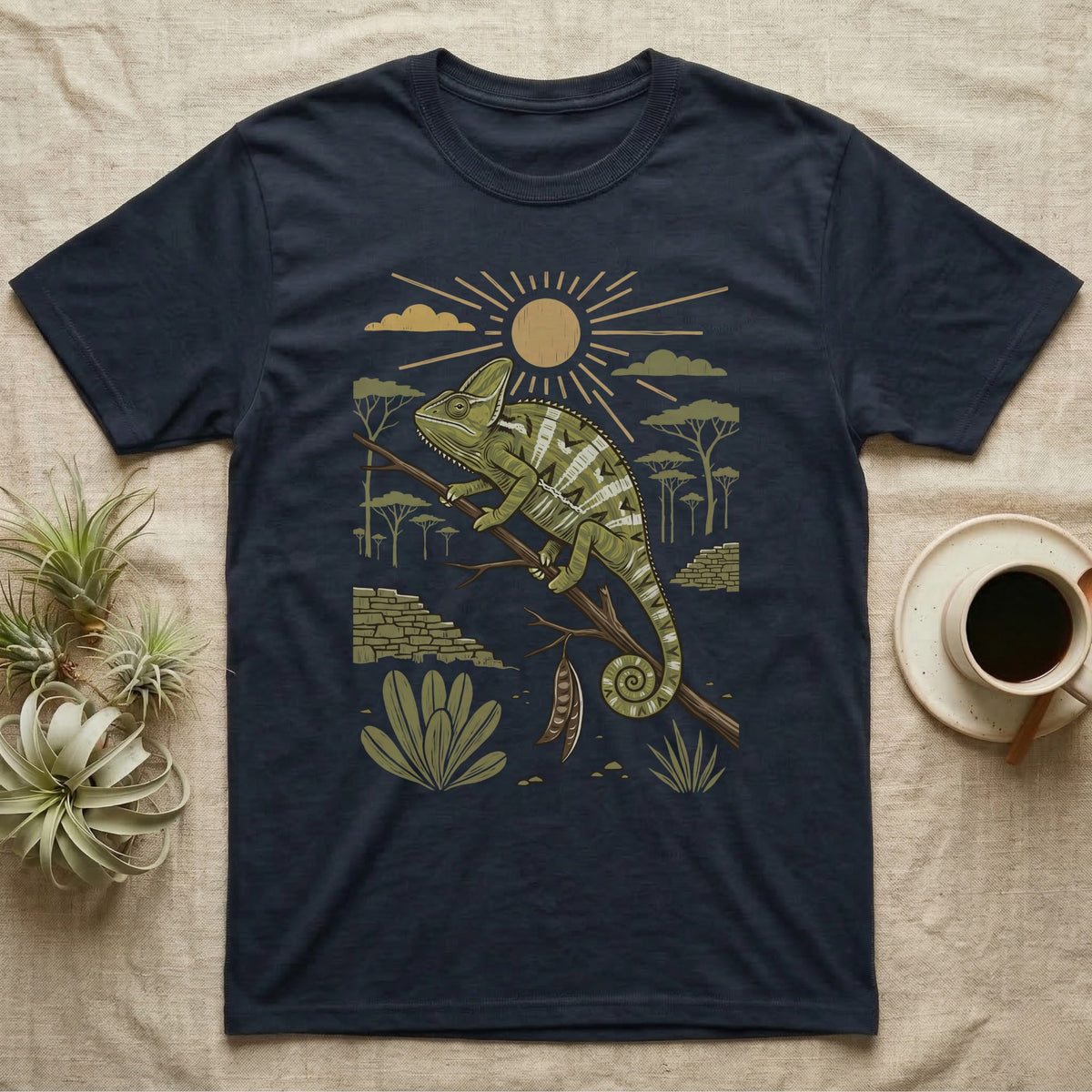 Veiled Chameleon Home Range T-Shirt in Navy — Woodcut-style illustration of a veiled chameleon gripping an acacia branch with terraced walls and umbrella trees behind, no on-shirt text.