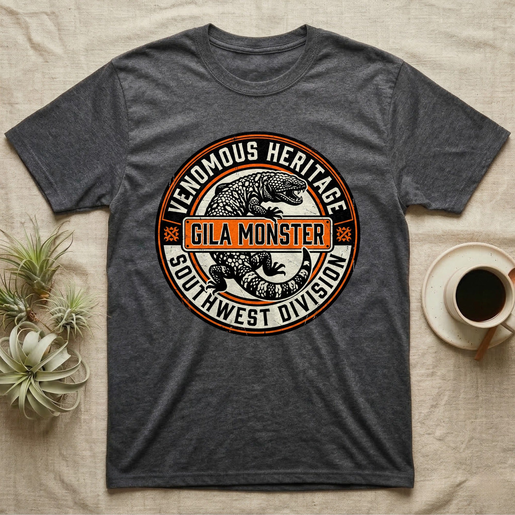 Dark gray t-shirt with "Venomous Heritage Southwest Division Gila Monster" circular logo.