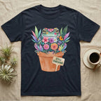 Tree Frog Thriving T-Shirt in Navy — A White's tree frog made of watercolour flowers, sitting in a terracotta pot with a plant label reading STILL THRIVING.