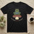 Black t-shirt with frog sitting on a mushroom, "Let me be weird in peace" text.