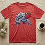 Sulcata Strawberry Tortoise T-Shirt in Heather Red — Bold vector illustration of a sulcata tortoise lunging neck-first toward an oversized red strawberry, head-on view.