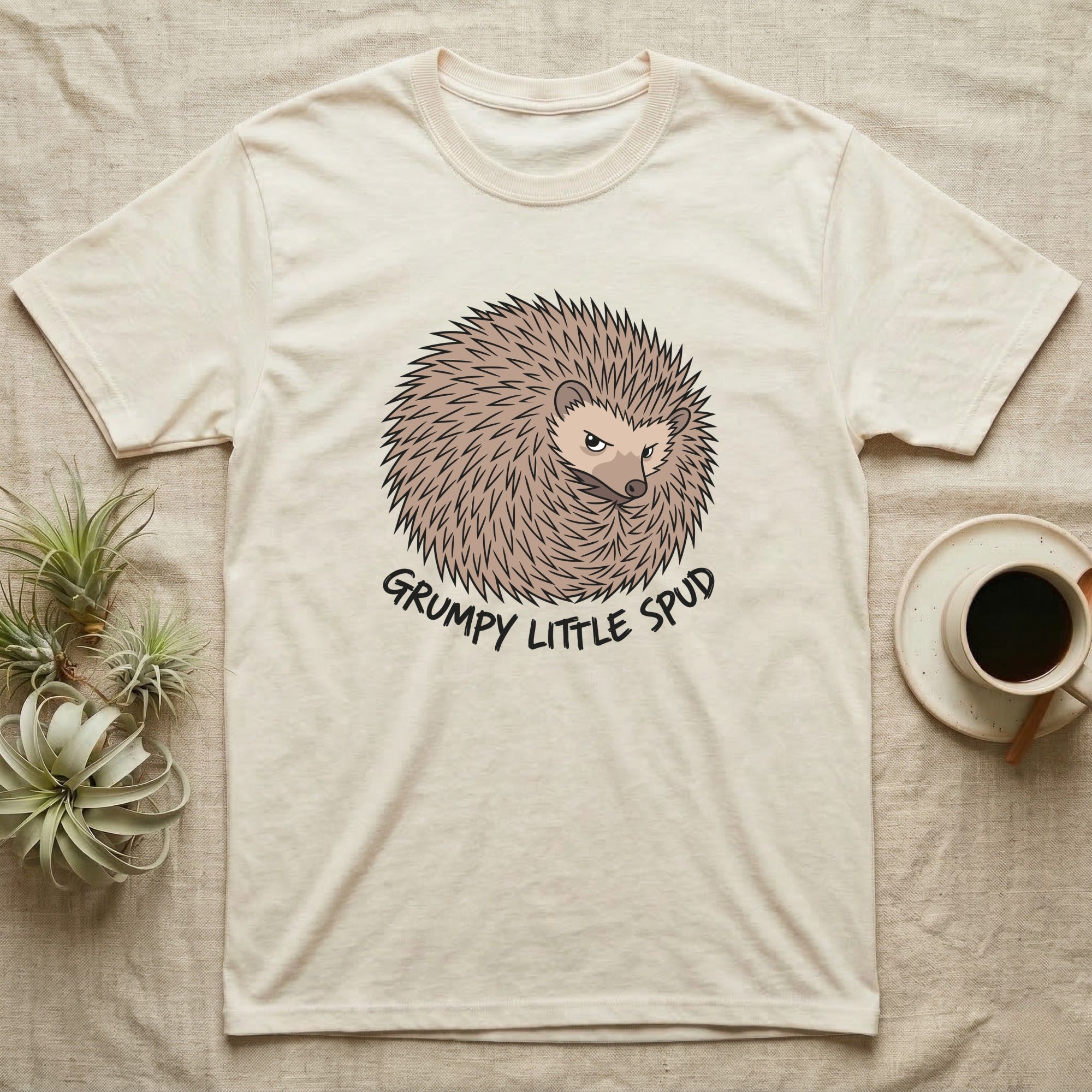 Cream t-shirt with a cartoon hedgehog graphic and "Grumpy Little Spud" text.