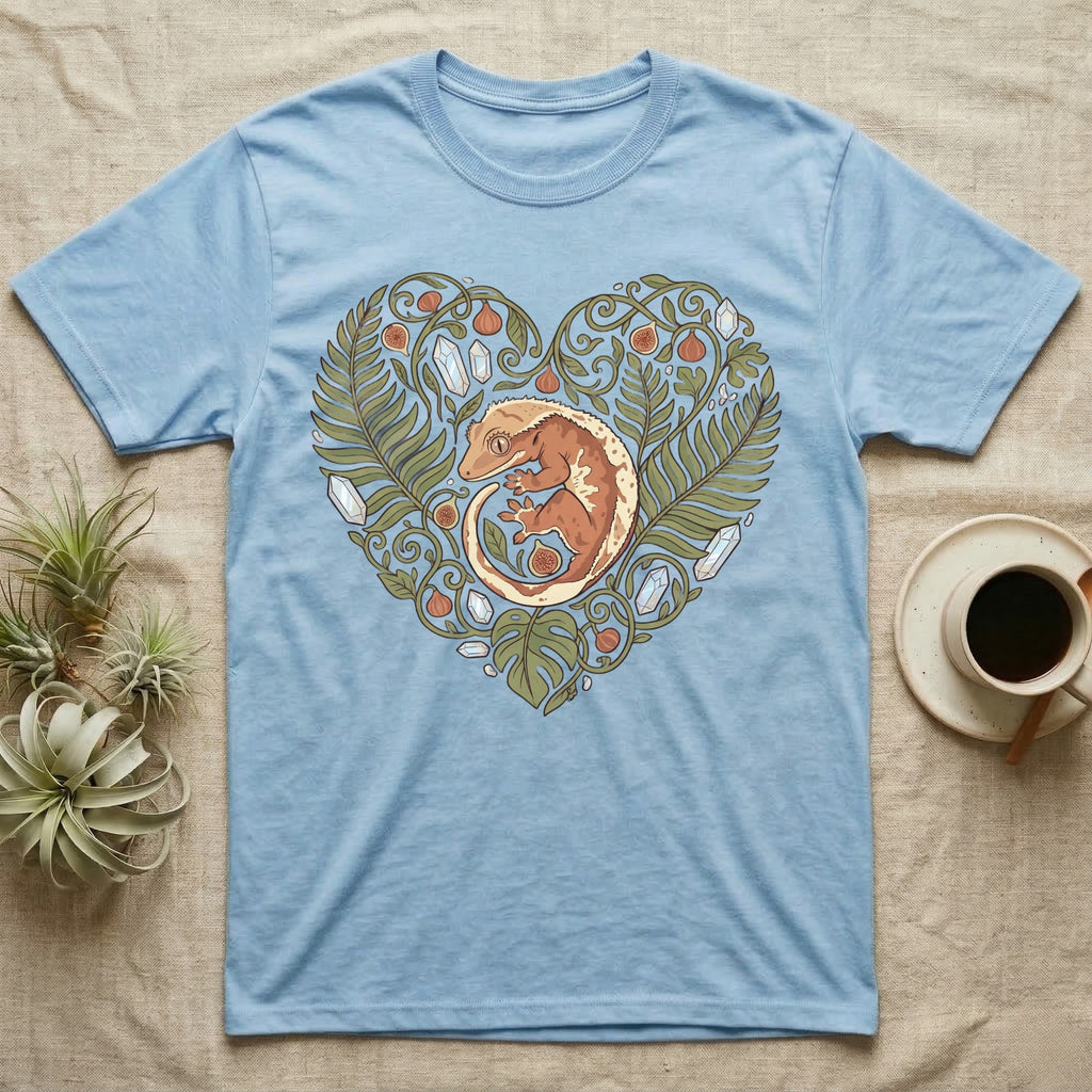 Light blue t-shirt with a crested gecko in a heart-shaped leaf and crystal design.