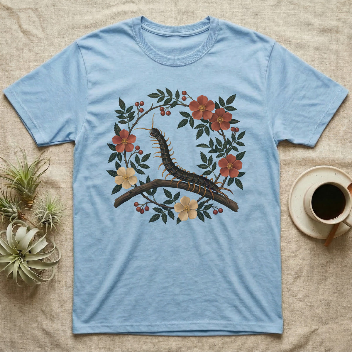 Vietnamese Centipede Botanical T-Shirt in Light Blue — Vietnamese giant centipede painted in matte oil, in profile on a branch inside an oval bower of flowering bramble.