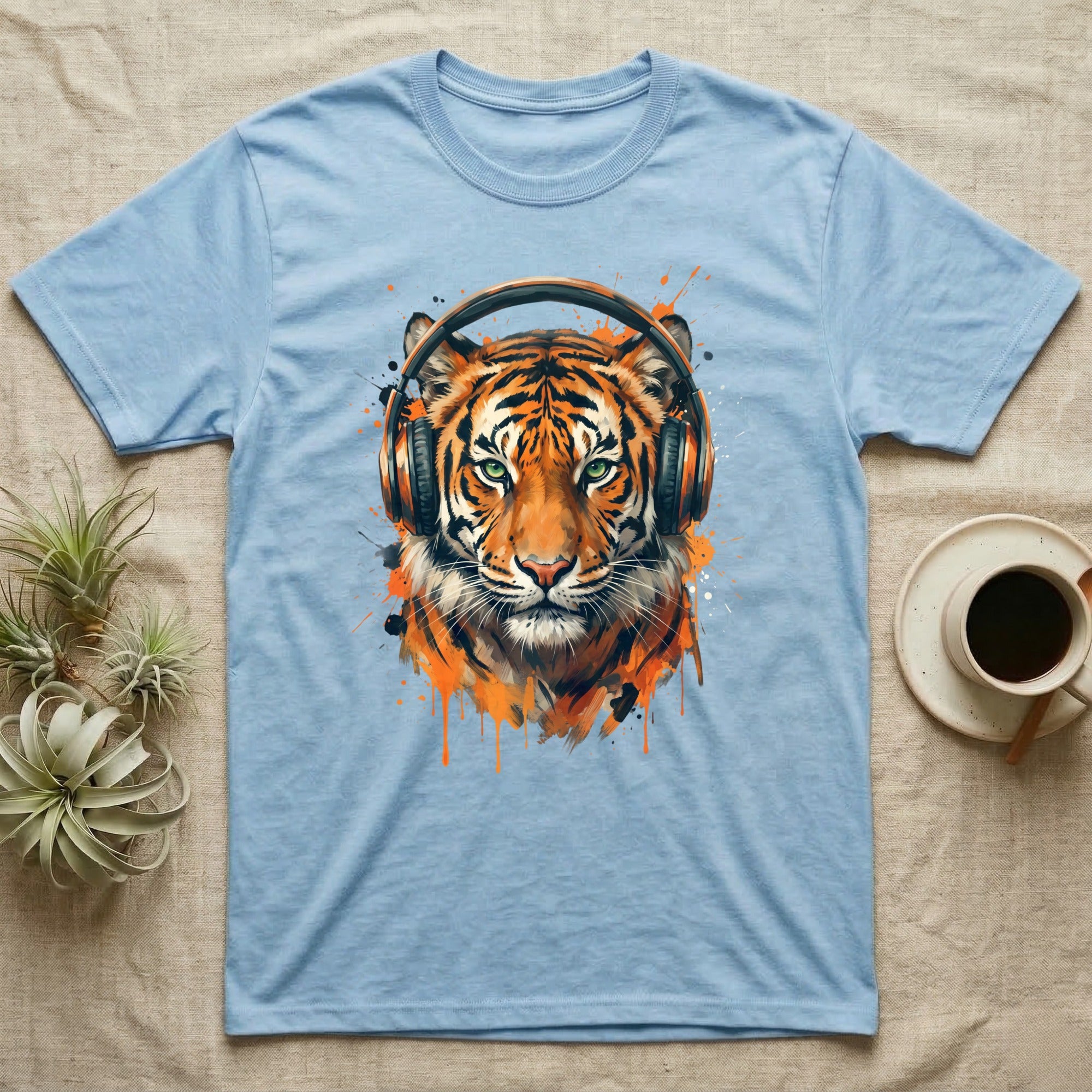 Light blue t-shirt featuring a tiger wearing headphones with orange paint splatters.