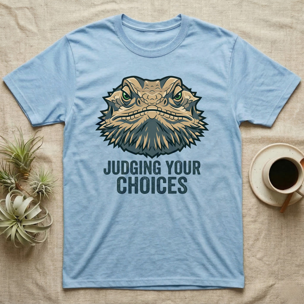 Light blue t-shirt with a cartoon lizard head and text "JUDGING YOUR CHOICES".