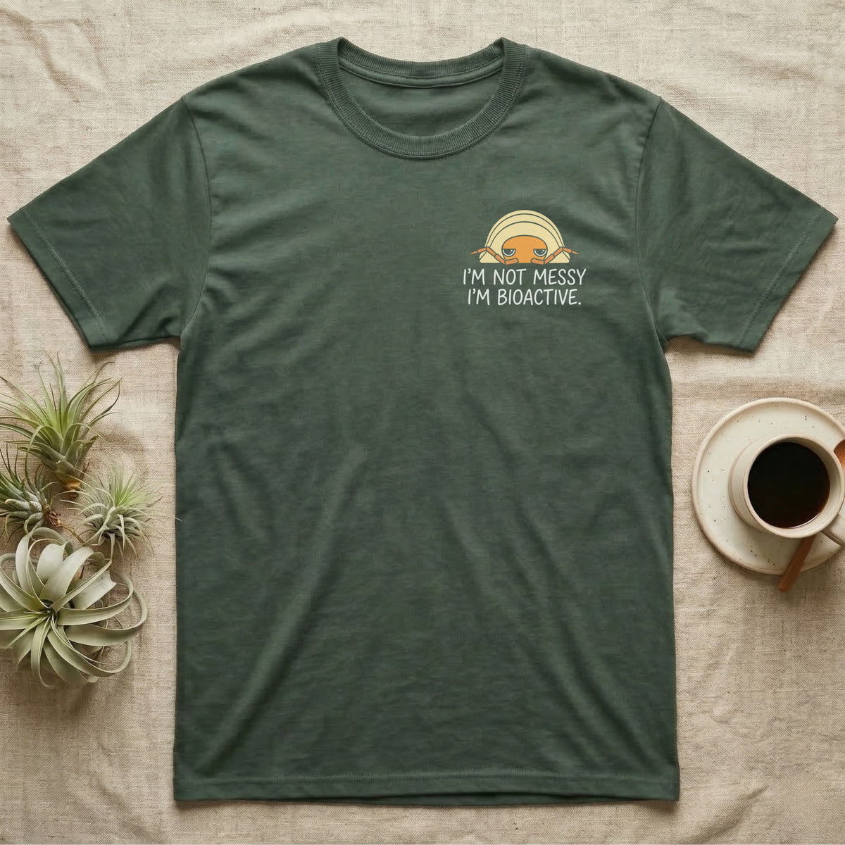 Bioactive Rubber Ducky T-Shirt in Military Green — Creamy-yellow rubber ducky isopod with an orange face peeking over white marker capitals reading I'M NOT MESSY I'M BIOACTIVE.