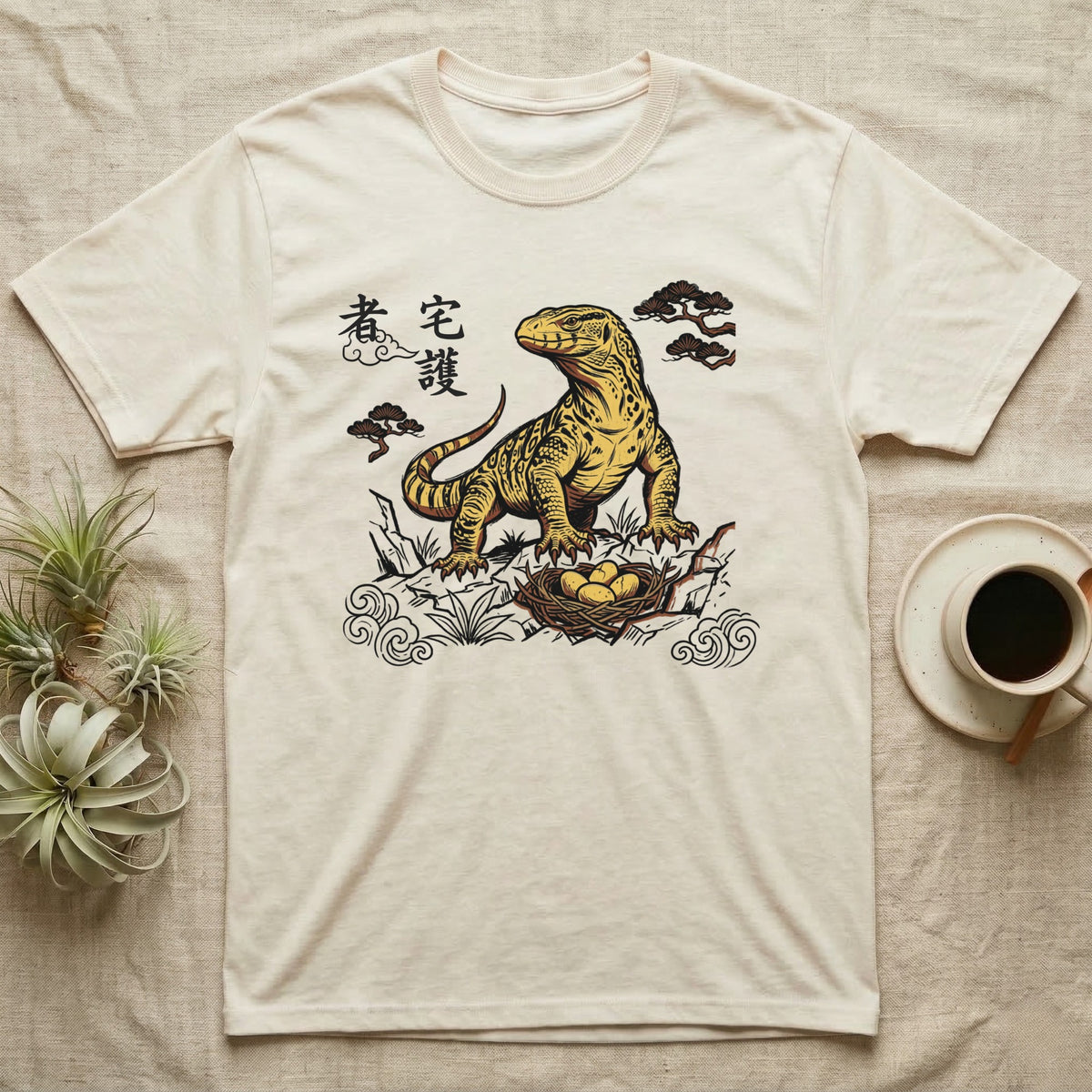 Cream t-shirt with yellow Komodo dragon and nest illustration with Japanese text.