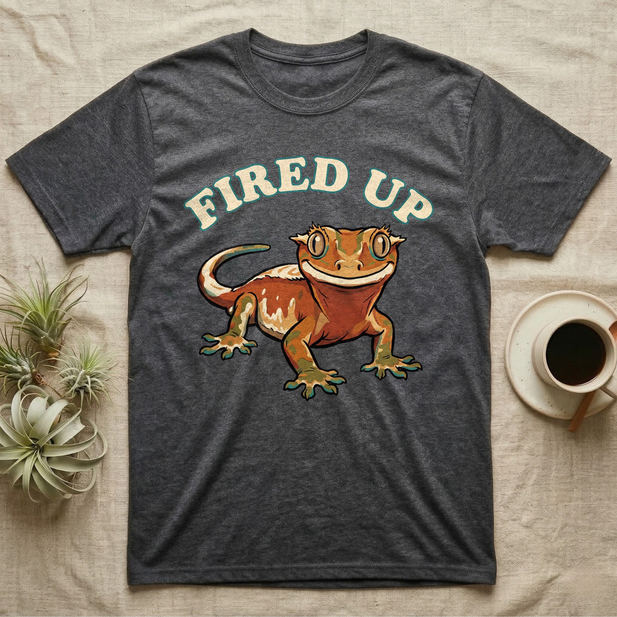 Fired Up Crested Gecko T-Shirt in Dark Heather — Retro 90s-style illustration of a fired-up crested gecko under a bold arc headline reading Fired Up.