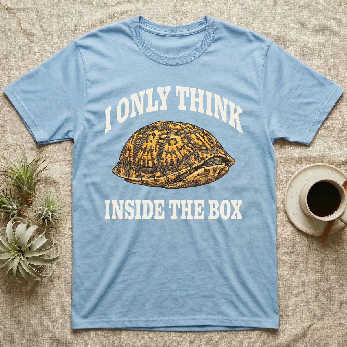 Box Turtle Thinker T-Shirt in Light Blue — Engraved eastern box turtle shut in its shell, one eye peeking out, under I Only Think Inside the Box