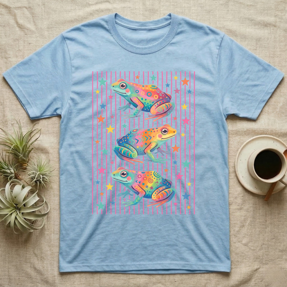 Dart Frog Disco Stripes T-Shirt in Light Blue — Three rainbow poison dart frog morphs stacked on a pink-and-cream candy-stripe field with scattered stars.