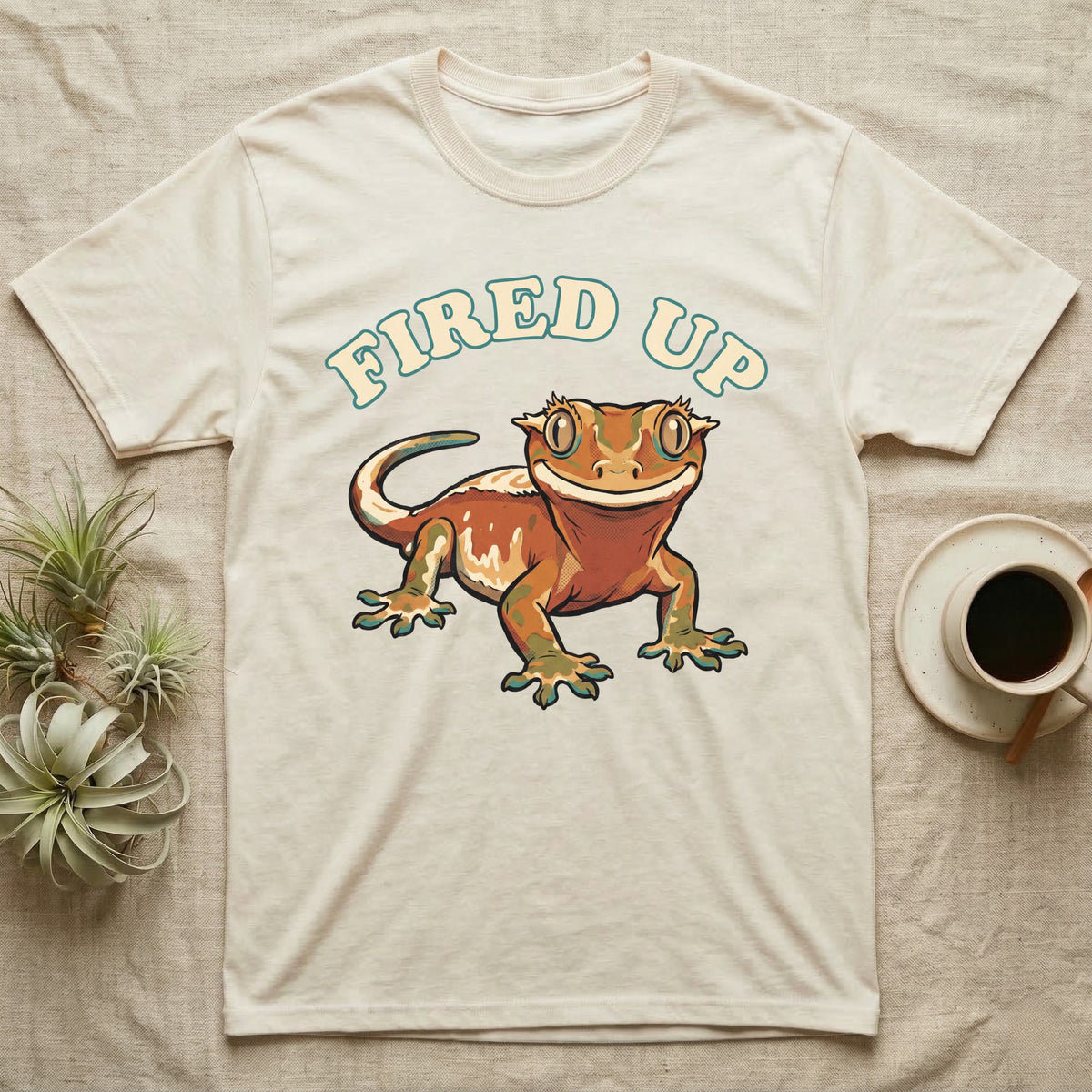 Fired Up Crested Gecko T-Shirt in Natural — Retro 90s-style illustration of a fired-up crested gecko under a bold arc headline reading Fired Up.