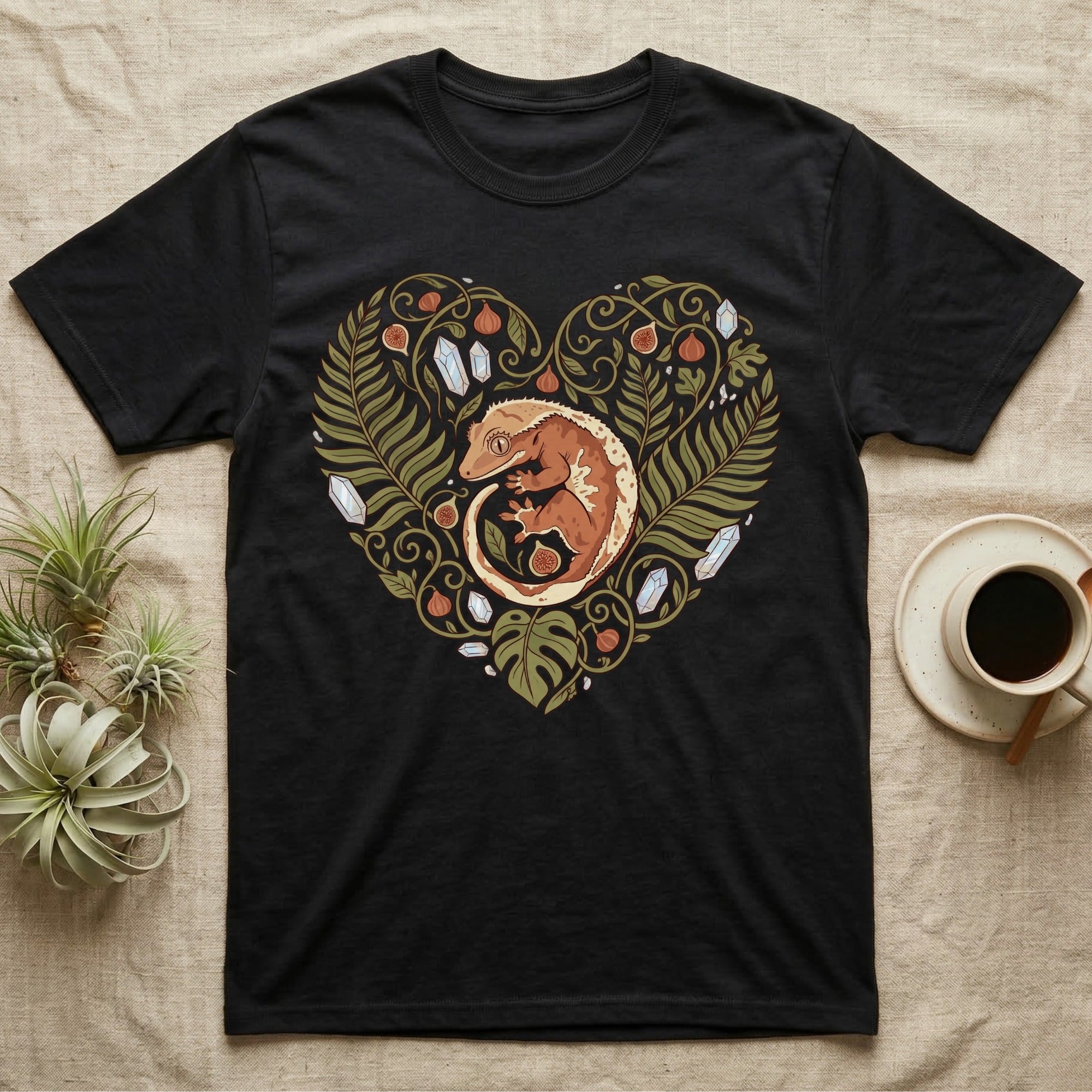 Black t-shirt with a heart-shaped design of a crested gecko and foliage.