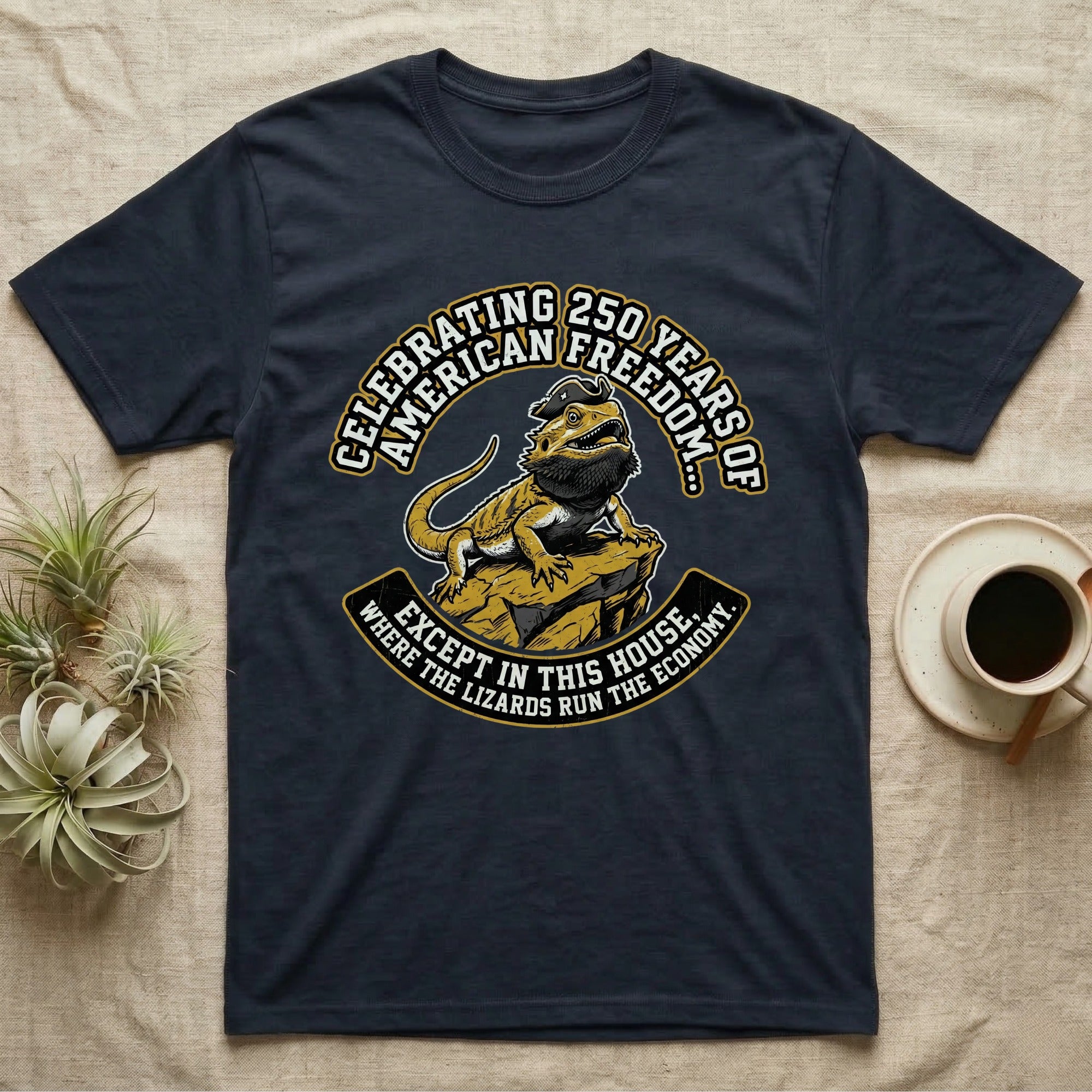 Bearded Dragon 1776 T-Shirt in Navy — Bold woodcut tee of a bearded dragon in a tricorn hat black-bearding on a rock, gold and cream banner reading the lizards run the economy.