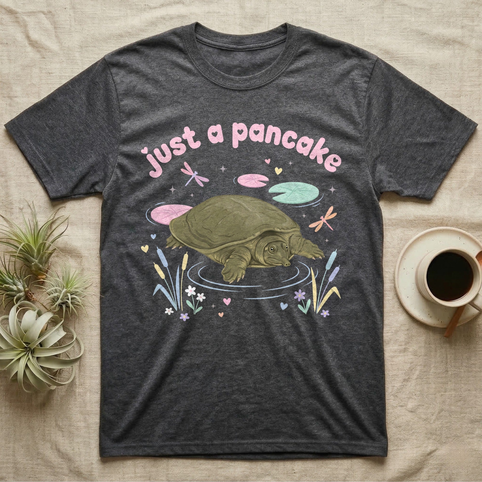 Spiny Softshell Turtle Baby T-Shirt in Dark Heather — Pastel spiny softshell turtle with flat shell and snorkel nose among lily pads, puffy pink wordmark "just a pancake" above.