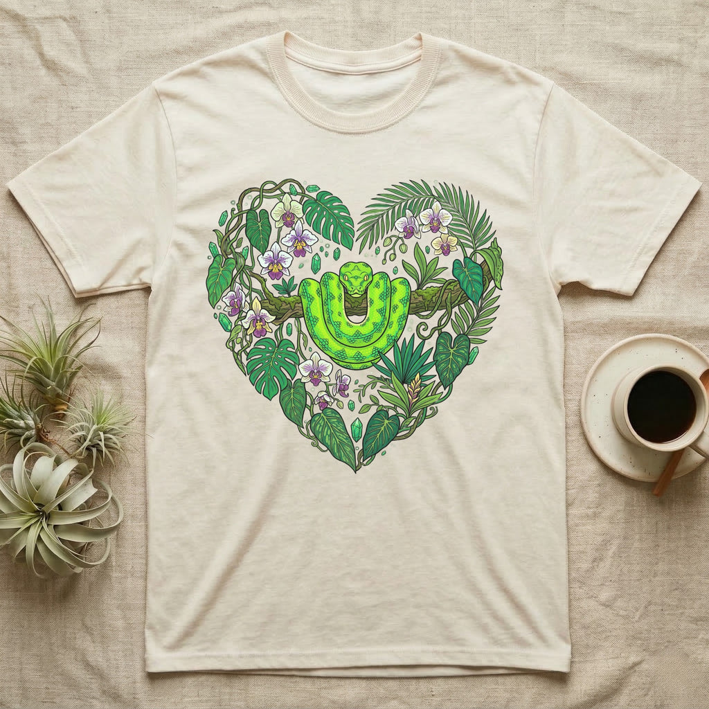 Green snake and tropical leaves form a heart shape on a cream t-shirt.