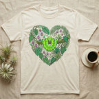 Green snake and tropical leaves form a heart shape on a cream t-shirt.