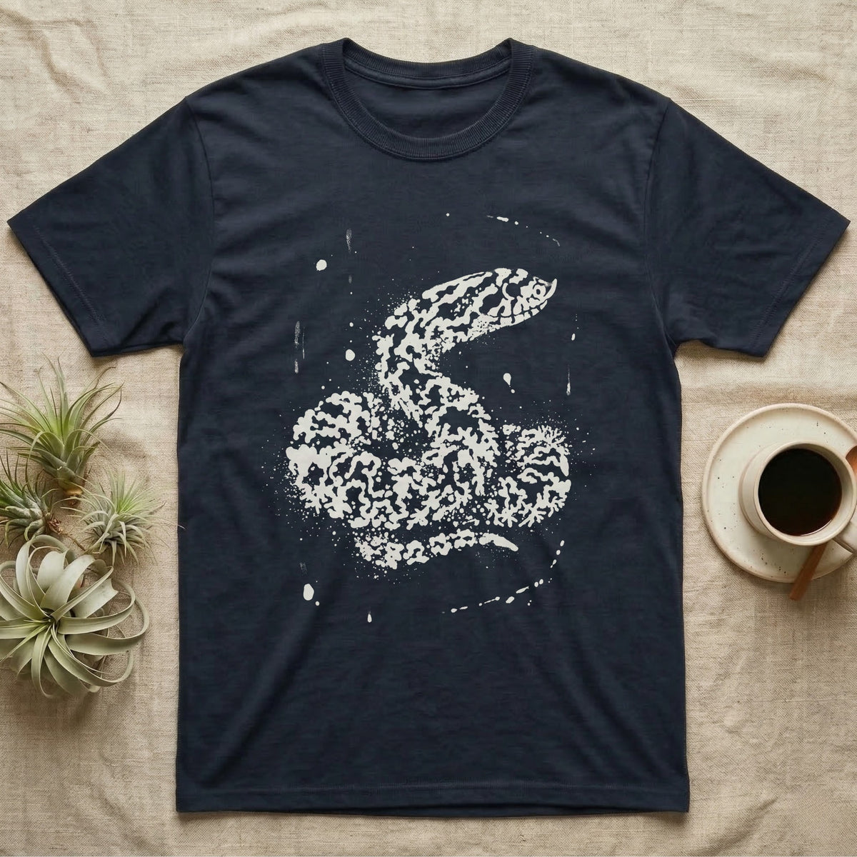 Hognose Bleach Spatter T-Shirt in Navy — A western hognose snake formed from pale bleach spatter on a near-black ground, head turned to show its upturned snout.