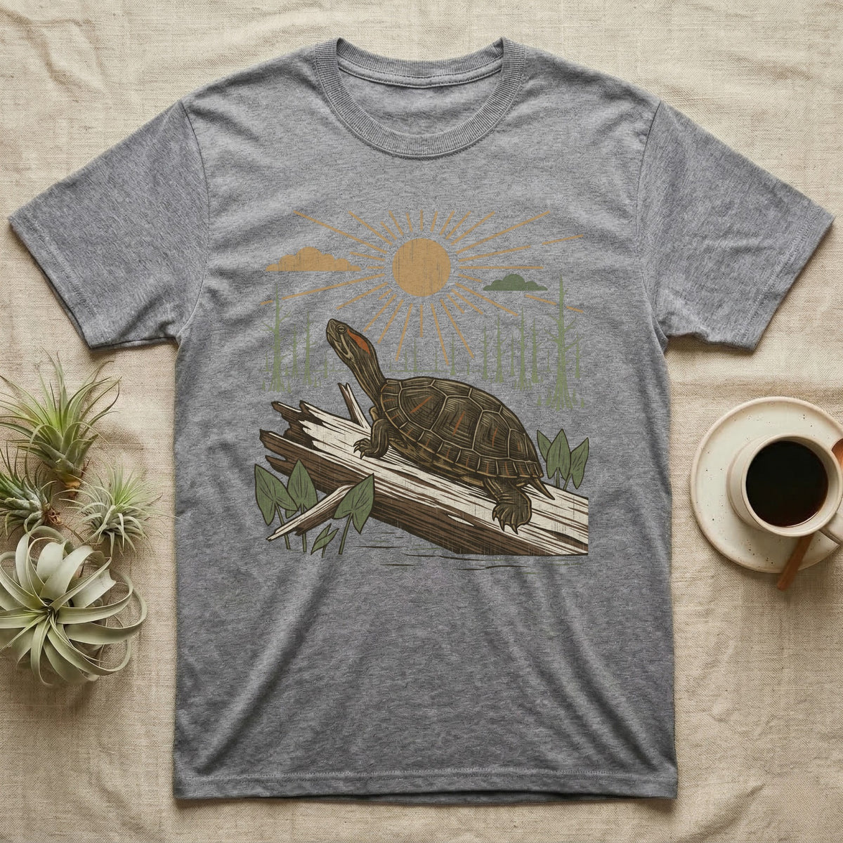 Red-Eared Slider Home Range T-Shirt in Sport Grey — Woodcut-style illustration of a red-eared slider basking on a half-sunk log in a cypress swamp under a full sun, no on-shirt text.
