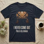 Deadpan photographic mugshot of an African fat-tailed gecko half in shadow above the distressed text I Never Come Out, this is by choice. — shown on a Navy tee.