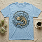 Light blue t-shirt with a tan axolotl graphic and "Monstrum Aquosum" text.