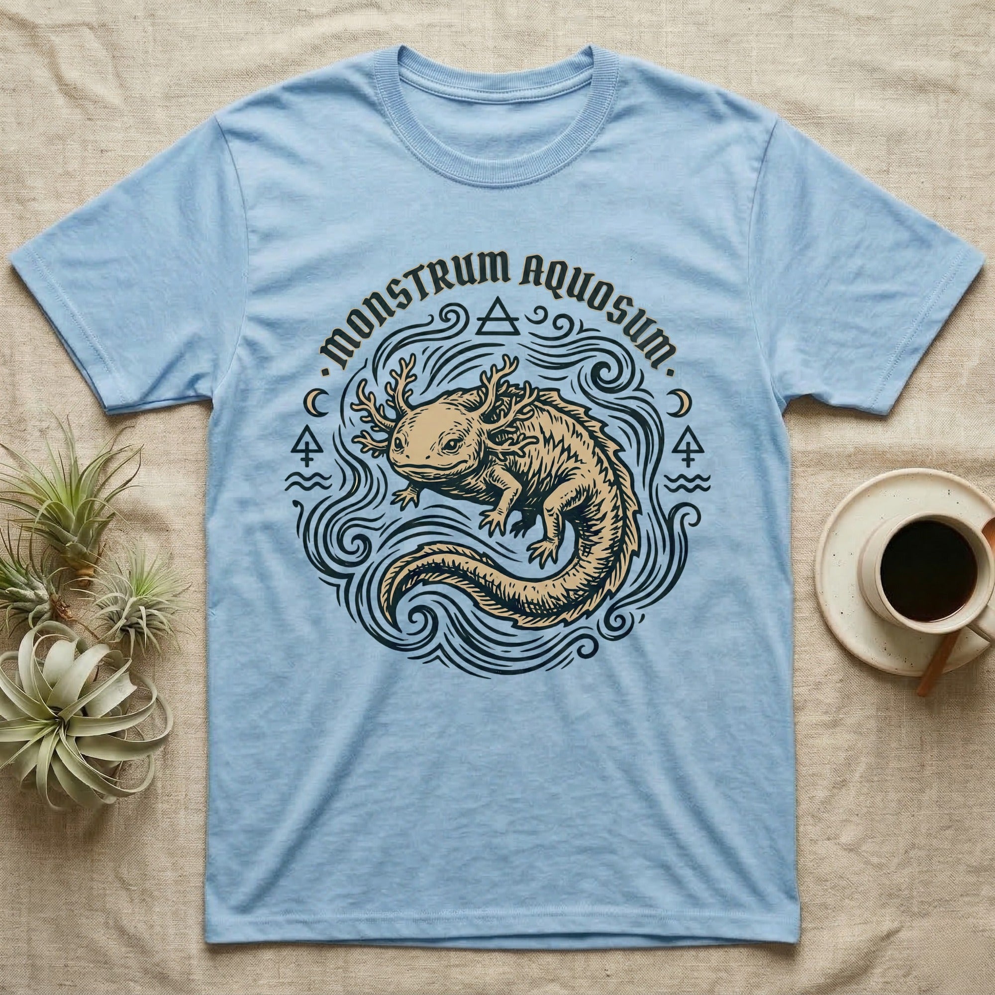 Light blue t-shirt with a tan axolotl graphic and "Monstrum Aquosum" text.
