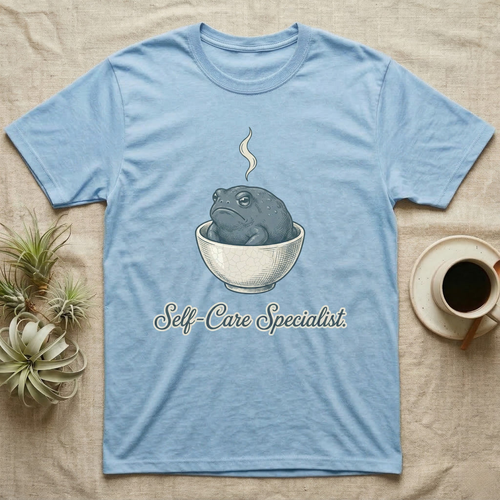 Light blue t-shirt with a toad in a bowl and "Self-Care Specialist" text.