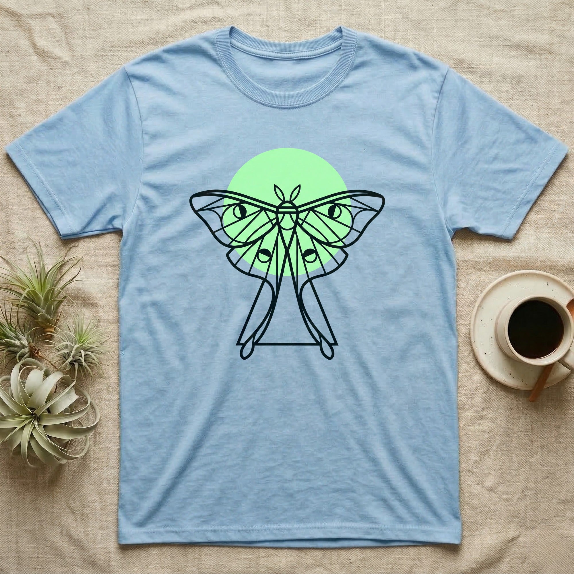 Light blue t-shirt with a stylized moth and moon design.