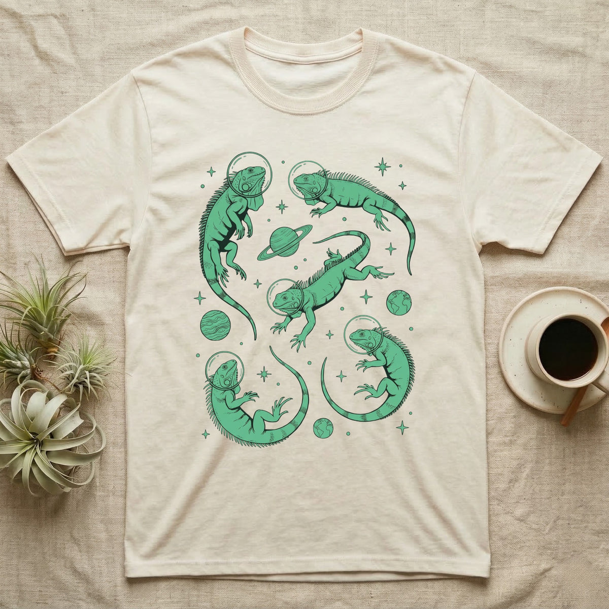 Green Iguana Cosmic T-Shirt in Natural — Vintage screen-print illustration of green iguanas in astronaut helmets floating in space, cosmic emerald green monochromatic on dark background.