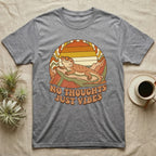 Gray t-shirt with a retro graphic of a bearded dragon and "NO THOUGHTS JUST VIBES" text.