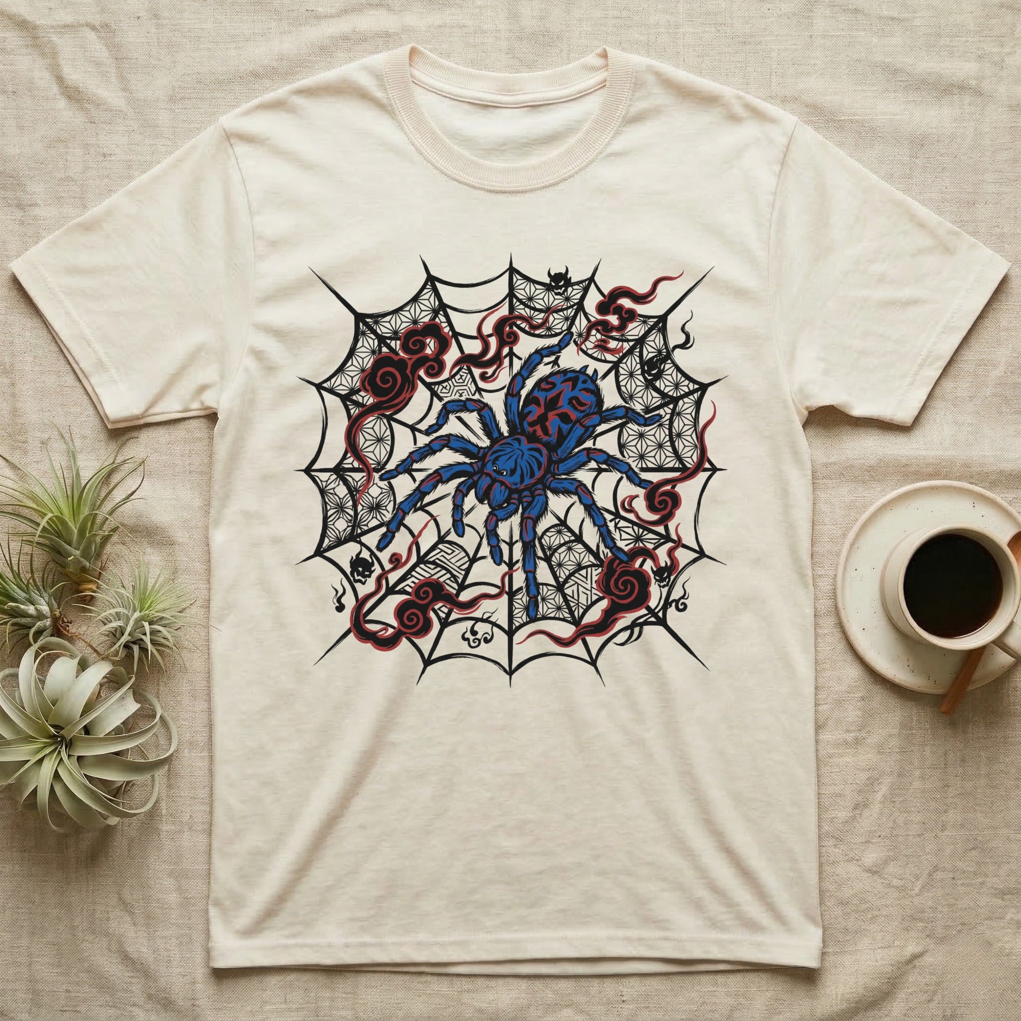 T-shirt with a blue tarantula on a spiderweb with red accents.
