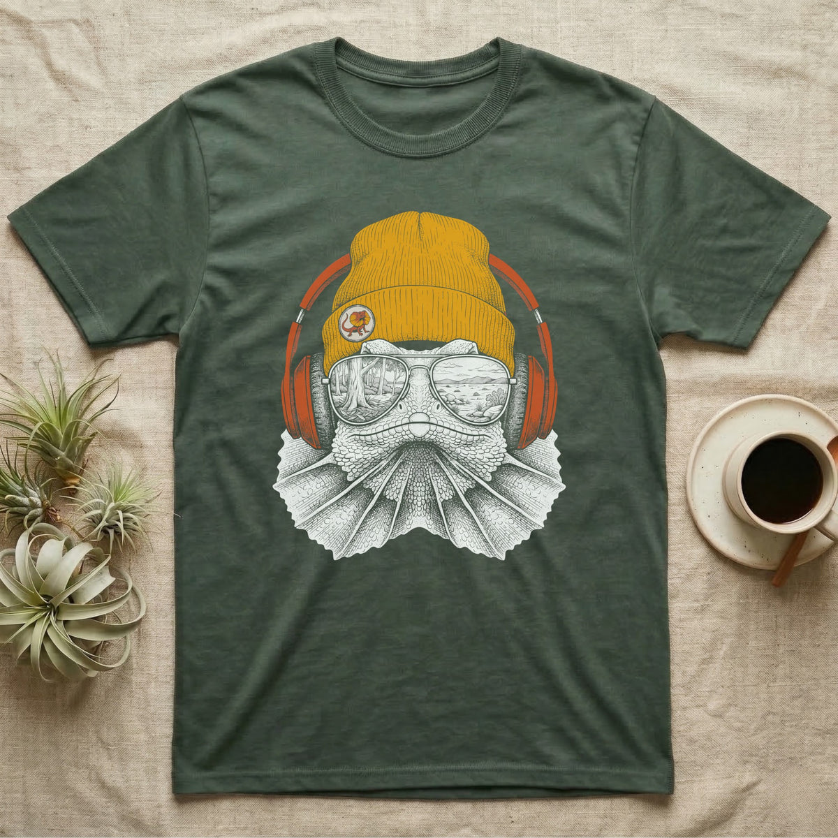 Frilled Lizard Headphones T-Shirt in Military Green — Engraved frilled lizard with fanned frill in a beanie and headphones, aviators reflecting savannah woodland.