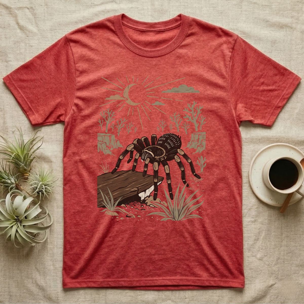 Red-Knee Tarantula Home Range T-Shirt in Heather Red — Woodcut-style illustration of a Mexican red-knee tarantula at its burrow entrance under a rock slab with desert scrub behind, no on-shirt text.