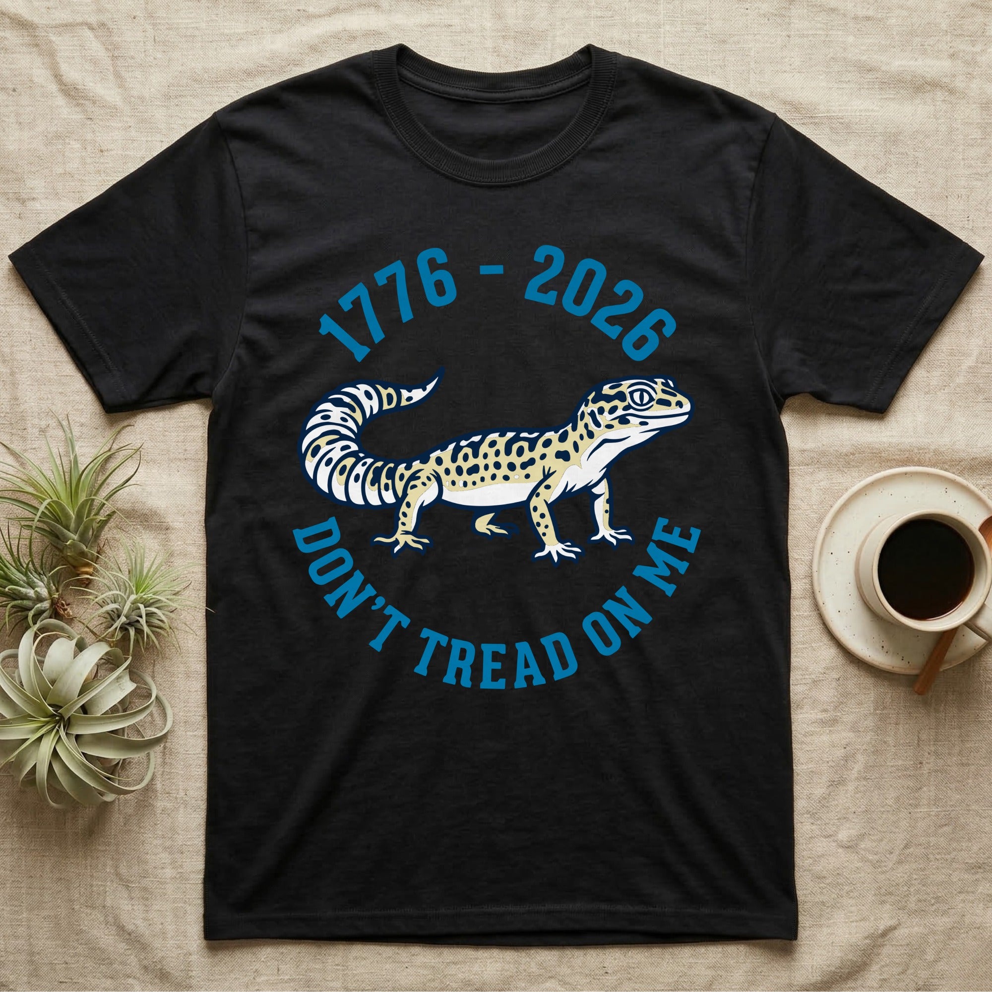 Leopard Gecko 1776 T-Shirt in Black — Two-colour vector leopard gecko in profile ringed by arched text reading 1776 to 2026 and Don't Tread On Me.