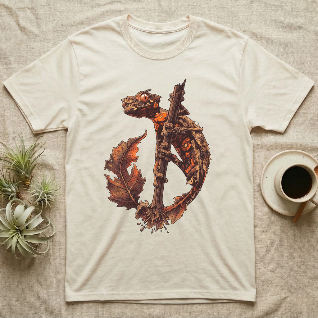 Vintage ink illustration of an eyelash leaf-tailed gecko clinging to a branch with its tail curled beside a serrated leaf, no on-shirt text. — shown on a Natural tee.