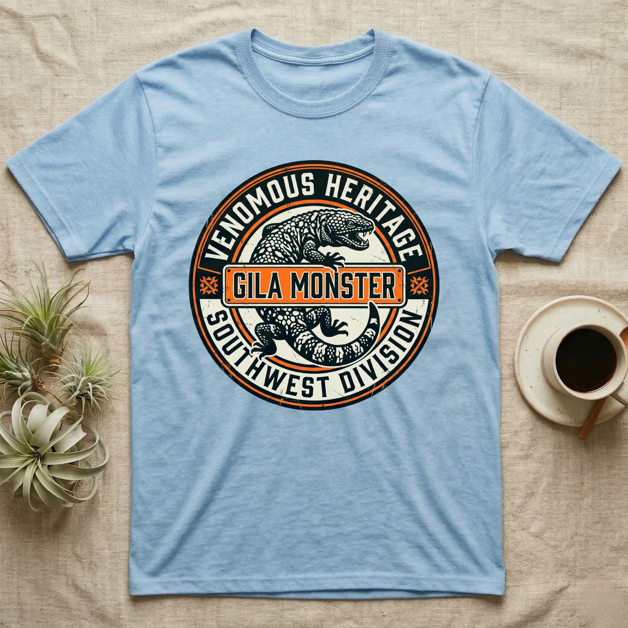 Light blue t-shirt with Gila Monster design, "Venomous Heritage Southwest Division".